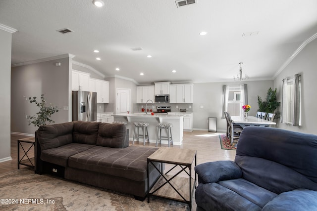 living room with ornamental molding, sink, vaulted ceiling, and light hardwood / wood-style flooring