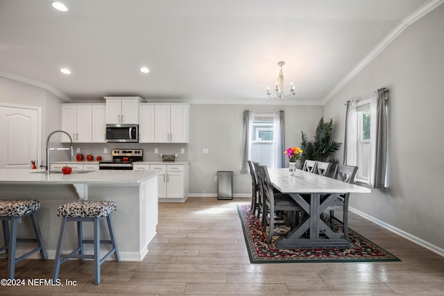 kitchen with sink, white cabinets, stainless steel appliances, and plenty of natural light