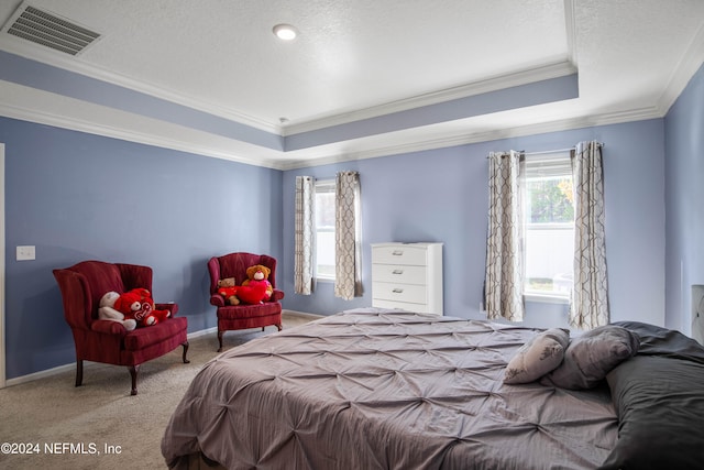 bedroom with light carpet, crown molding, a textured ceiling, and a raised ceiling