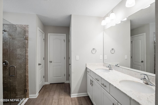 bathroom featuring vanity, a textured ceiling, hardwood / wood-style flooring, and walk in shower