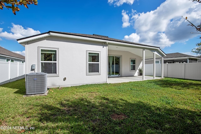 back of property with a patio, cooling unit, and a lawn