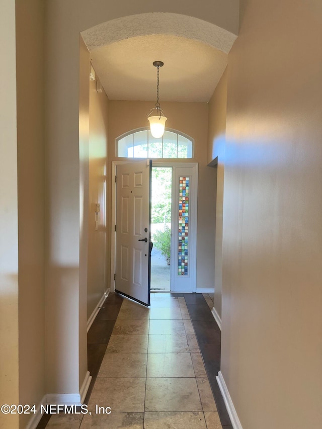 tiled foyer entrance featuring a textured ceiling