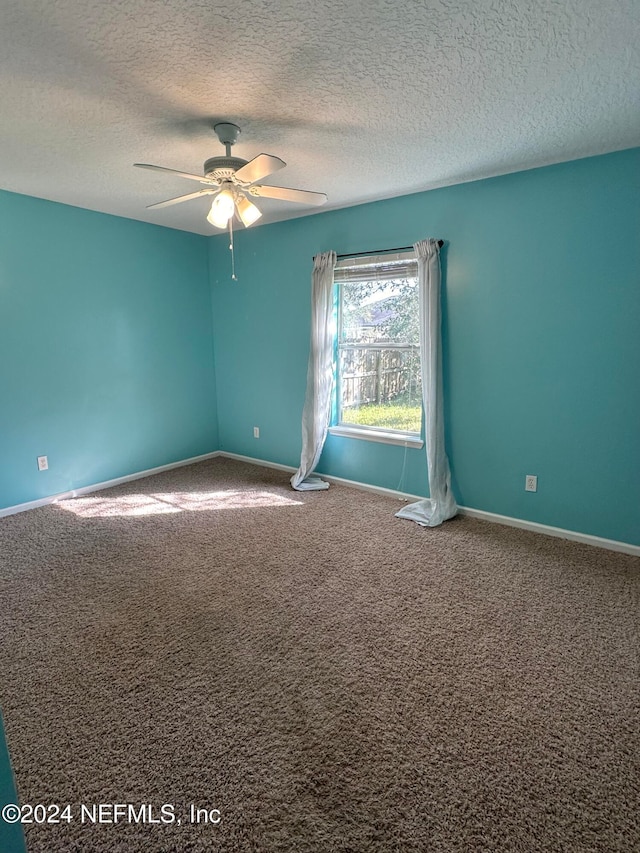 carpeted spare room with a textured ceiling and ceiling fan