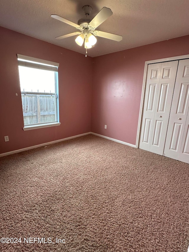 carpeted empty room featuring a textured ceiling and ceiling fan