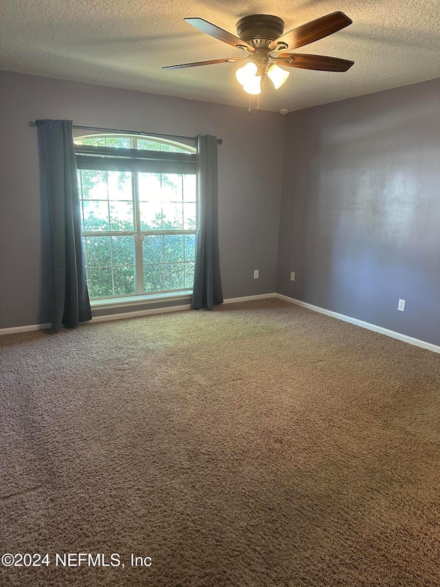 carpeted spare room with a textured ceiling and ceiling fan