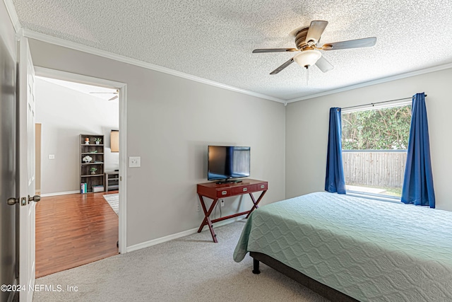 carpeted bedroom with ceiling fan, a textured ceiling, and ornamental molding