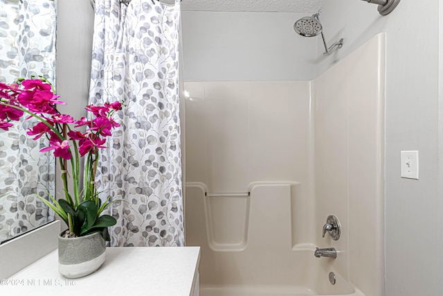 bathroom featuring vanity, shower / bath combination with curtain, and a textured ceiling