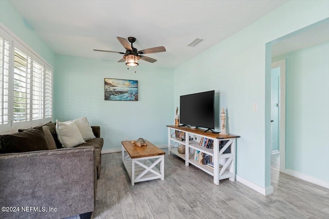 living room with light hardwood / wood-style floors and ceiling fan