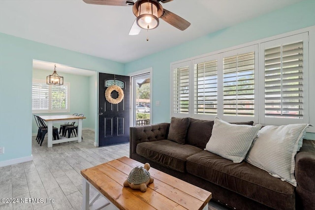 living room with light hardwood / wood-style floors, ceiling fan, and a wealth of natural light