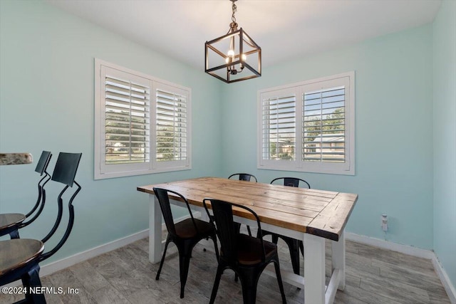 dining area featuring an inviting chandelier, a healthy amount of sunlight, and light wood-type flooring