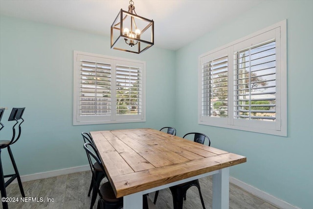 dining space with light hardwood / wood-style floors, a notable chandelier, and plenty of natural light