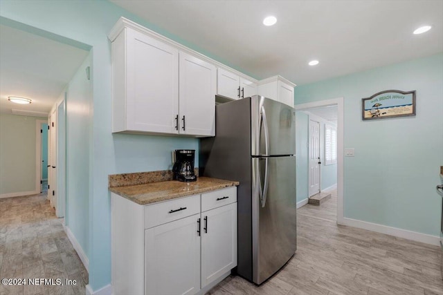 kitchen featuring white cabinetry, light wood-type flooring, and stainless steel refrigerator