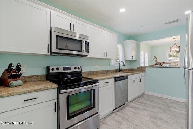 kitchen featuring sink, appliances with stainless steel finishes, white cabinets, and light hardwood / wood-style floors