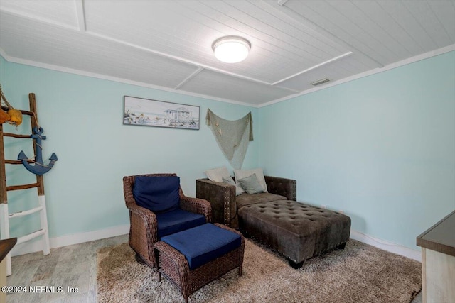 sitting room featuring wood-type flooring and ornamental molding