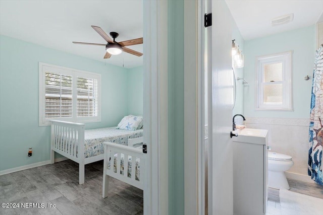 bedroom with sink, multiple windows, light hardwood / wood-style floors, and ceiling fan