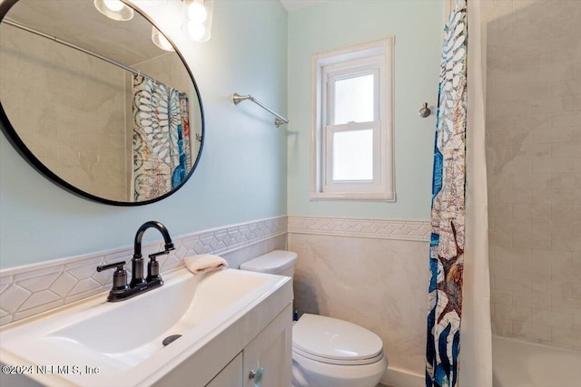 full bathroom featuring toilet, vanity, and tile walls