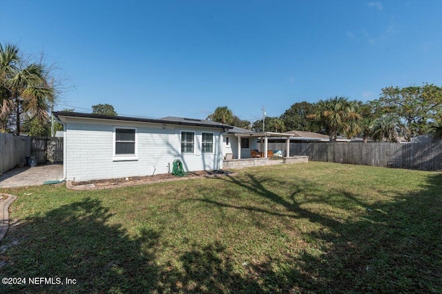 back of house with a yard and a patio area