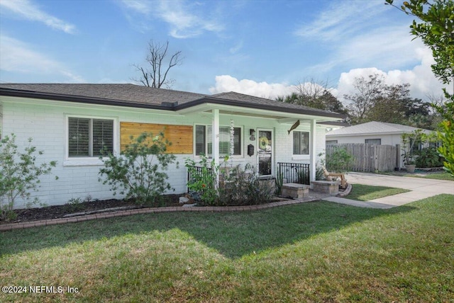 ranch-style house with a porch and a front lawn