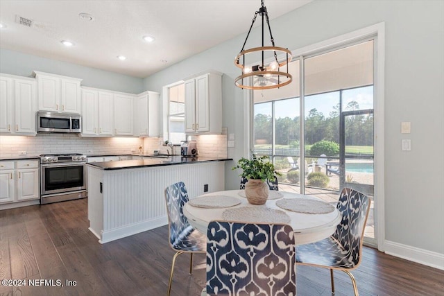 dining room with dark wood-type flooring, a chandelier, and plenty of natural light