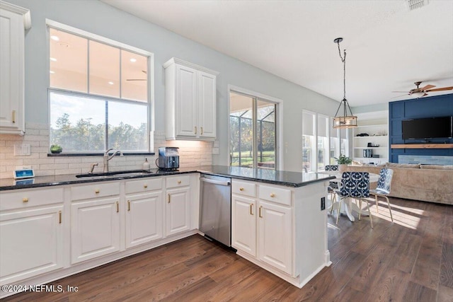 kitchen with sink, dark hardwood / wood-style flooring, kitchen peninsula, white cabinetry, and stainless steel dishwasher