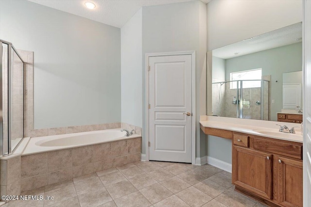 bathroom featuring vanity, a textured ceiling, independent shower and bath, and tile patterned floors