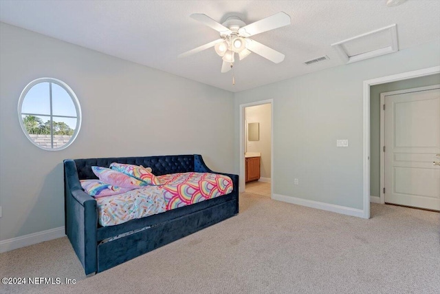 bedroom with ceiling fan, light carpet, and ensuite bath