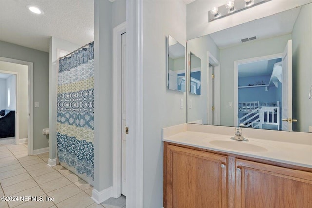 bathroom featuring vanity, a textured ceiling, a shower with curtain, and tile patterned flooring