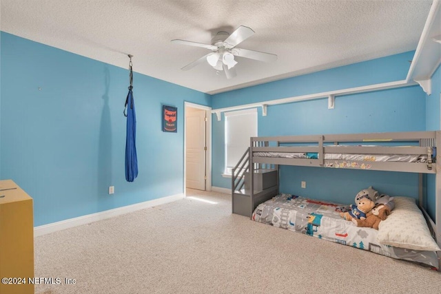 bedroom featuring ceiling fan, a textured ceiling, and carpet floors