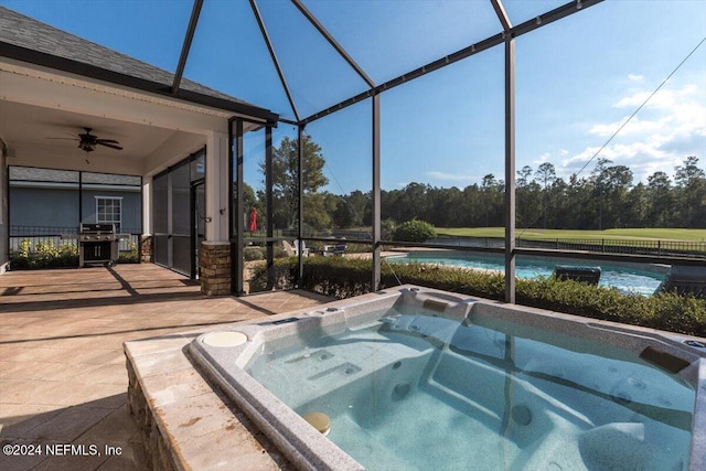 view of swimming pool featuring glass enclosure, an outdoor hot tub, a patio, ceiling fan, and a grill