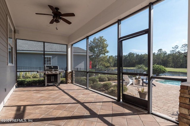 unfurnished sunroom with a swimming pool and ceiling fan