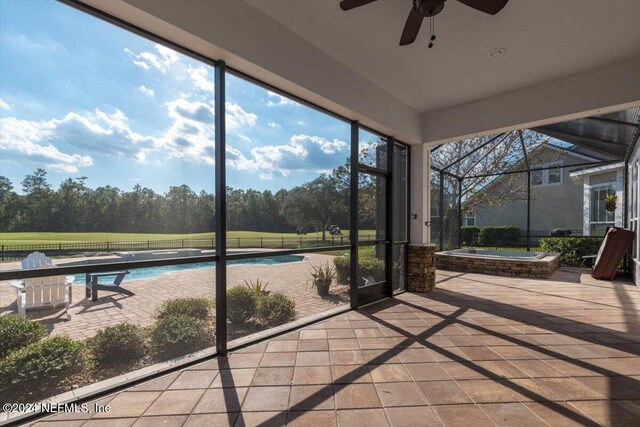 unfurnished sunroom with ceiling fan