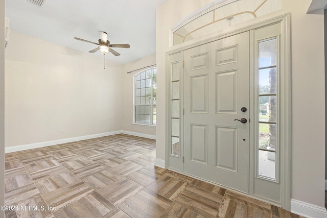 foyer with light parquet flooring, a wealth of natural light, and ceiling fan