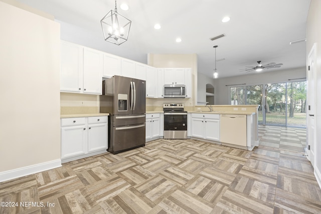 kitchen with ceiling fan with notable chandelier, kitchen peninsula, pendant lighting, appliances with stainless steel finishes, and white cabinetry