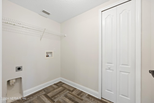 washroom featuring hookup for an electric dryer, washer hookup, a textured ceiling, and dark parquet floors