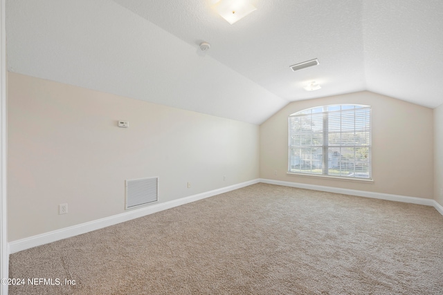 bonus room with a textured ceiling, vaulted ceiling, and carpet floors