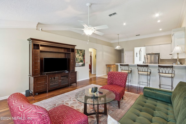 living room featuring ornamental molding, dark hardwood / wood-style floors, a textured ceiling, and ceiling fan