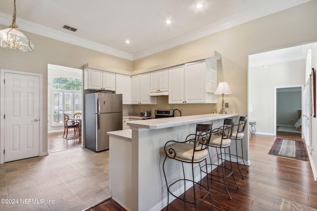 kitchen featuring appliances with stainless steel finishes, white cabinetry, and light hardwood / wood-style floors