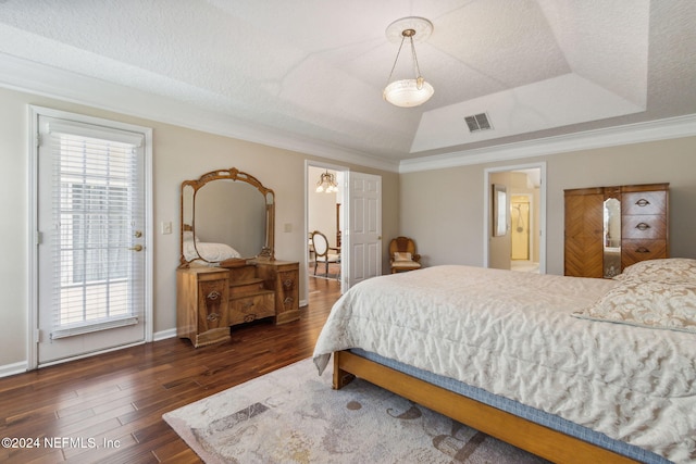 bedroom with ensuite bathroom, a raised ceiling, a textured ceiling, dark hardwood / wood-style flooring, and ornamental molding