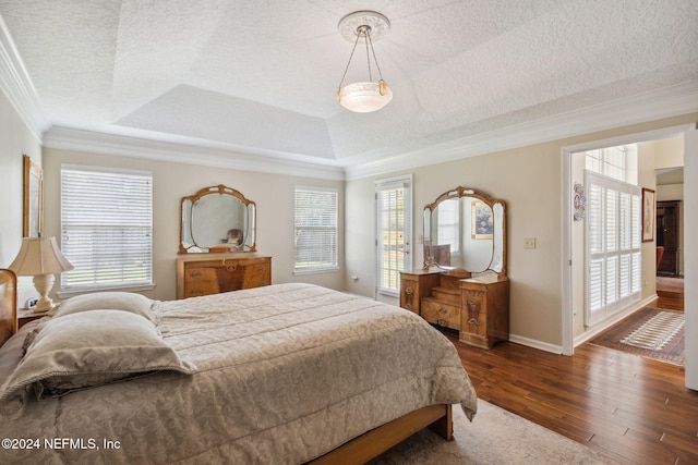 bedroom with multiple windows, a tray ceiling, dark wood-type flooring, and crown molding