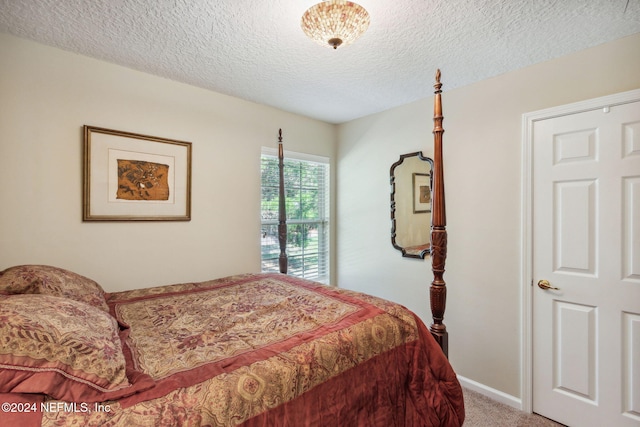 bedroom with a textured ceiling and carpet