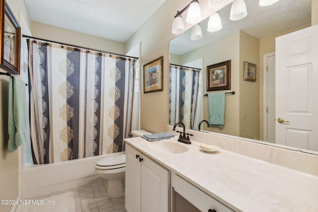 full bathroom featuring tile patterned floors, toilet, shower / tub combo with curtain, vanity, and a textured ceiling