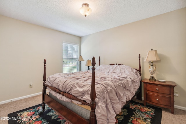 bedroom with light carpet and a textured ceiling