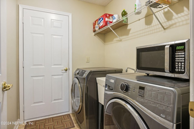 laundry room with parquet flooring and washer and clothes dryer