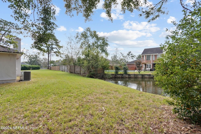 view of yard featuring central air condition unit and a water view