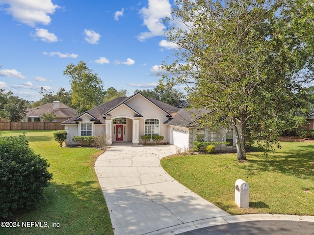 single story home with a garage and a front lawn