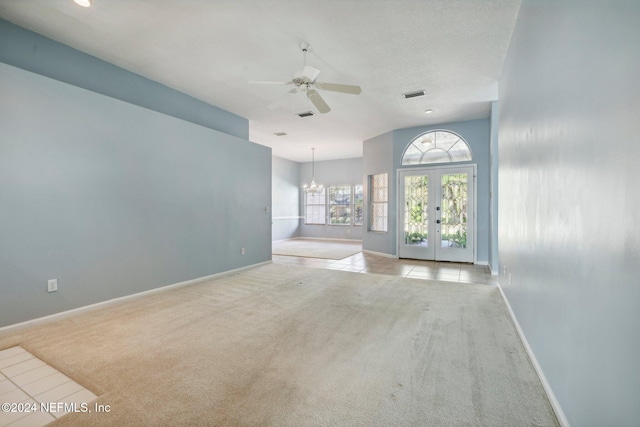 unfurnished living room with light carpet, french doors, and ceiling fan with notable chandelier