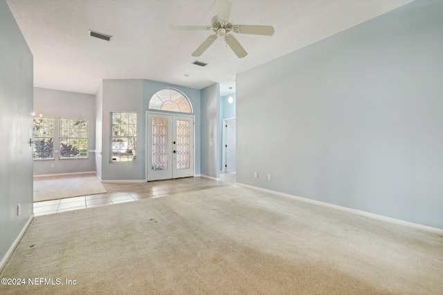 carpeted spare room featuring french doors, a textured ceiling, and ceiling fan