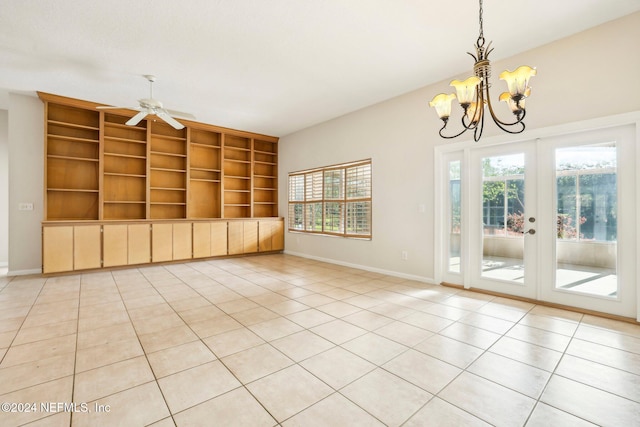 interior space featuring french doors, light tile patterned flooring, and ceiling fan with notable chandelier