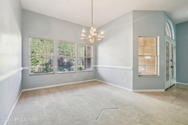 empty room with light carpet and a chandelier