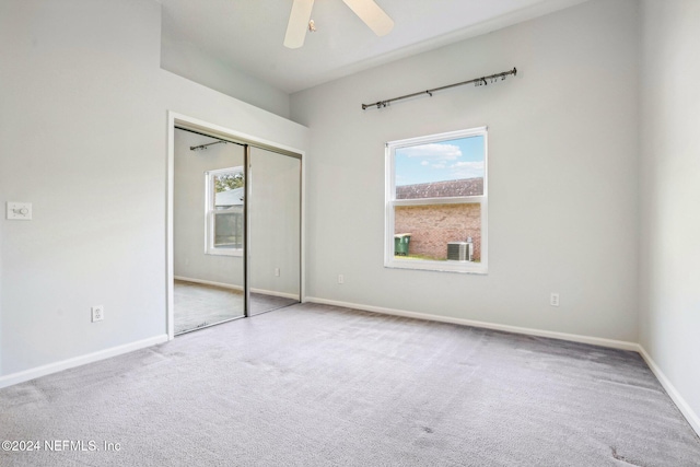 unfurnished bedroom with carpet, a closet, and ceiling fan